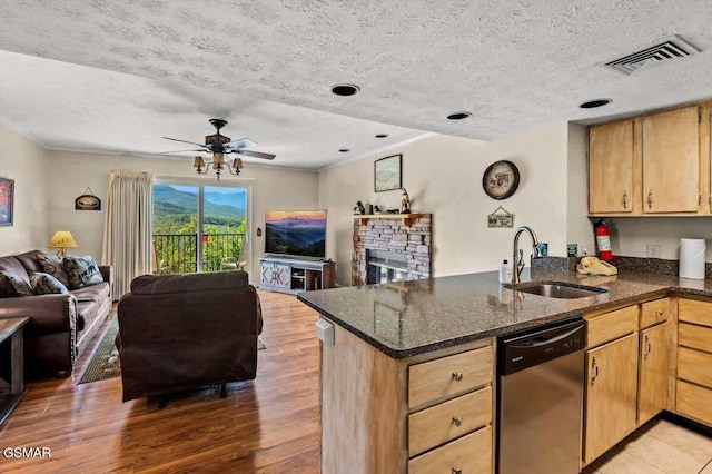 kitchen featuring visible vents, open floor plan, dishwasher, a peninsula, and a sink