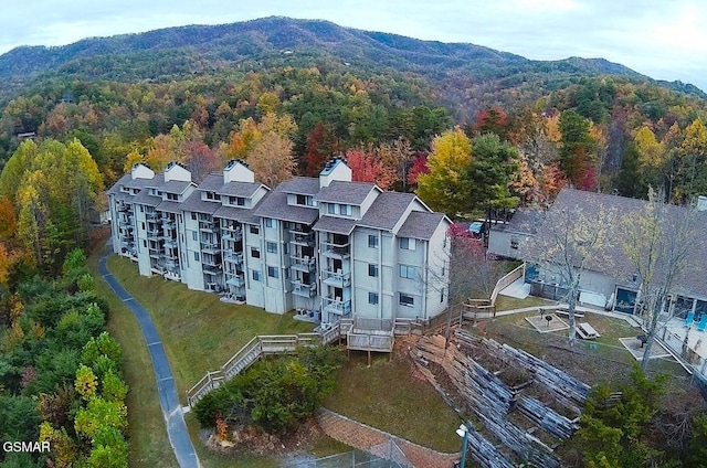 birds eye view of property featuring a wooded view and a mountain view