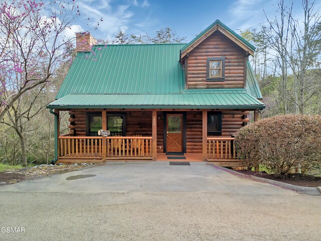 3416 Merlin Way, Pigeon Forge, TN 37863 - log cabin featuring a porch, log siding, a chimney, and a metal roof