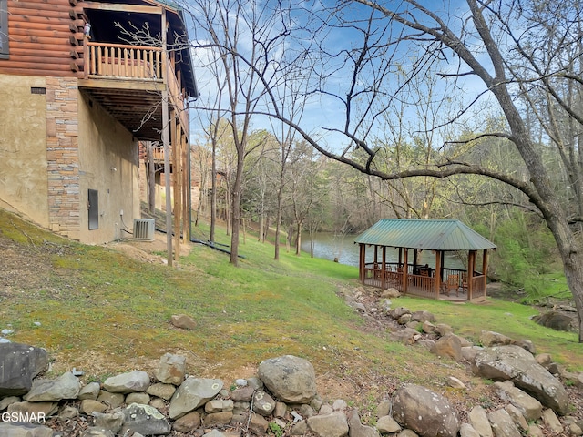 view of yard featuring central AC, a gazebo, and a water view