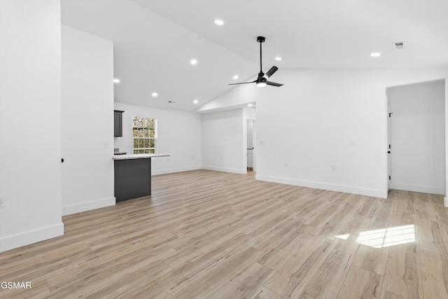 unfurnished living room with ceiling fan, light wood-type flooring, and vaulted ceiling