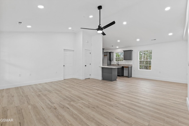 unfurnished living room with ceiling fan and light hardwood / wood-style floors