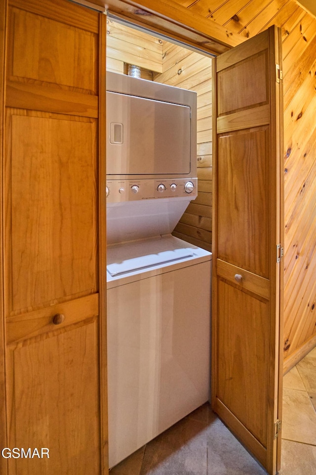 820 Pinnacle Vista Rd, Gatlinburg, TN 37738 - washroom featuring stacked washer and clothes dryer, wooden walls, and tile patterned floors