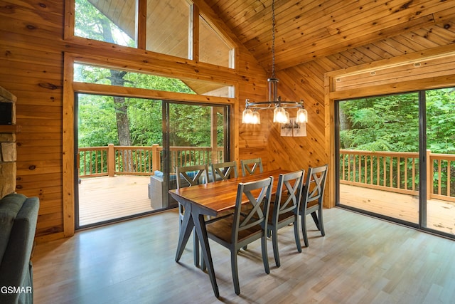 820 Pinnacle Vista Rd, Gatlinburg, TN 37738 - dining space with a chandelier, wooden walls, vaulted ceiling, and light wood-style floors