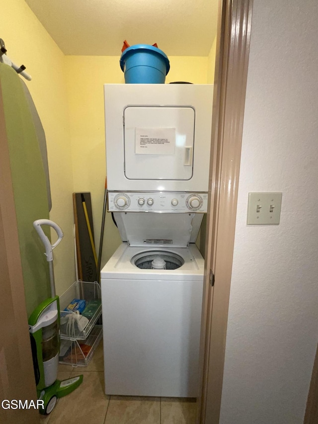 washroom with stacked washer / dryer and tile patterned flooring