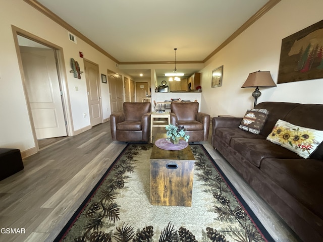 living room featuring wood finished floors, ornamental molding, and baseboards
