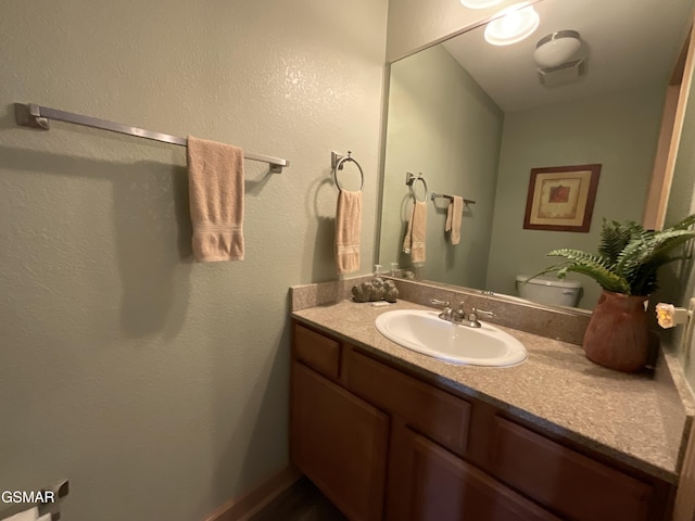 bathroom featuring vanity and toilet