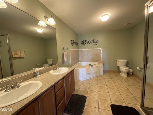 full bath with toilet, tile patterned flooring, a garden tub, and double vanity