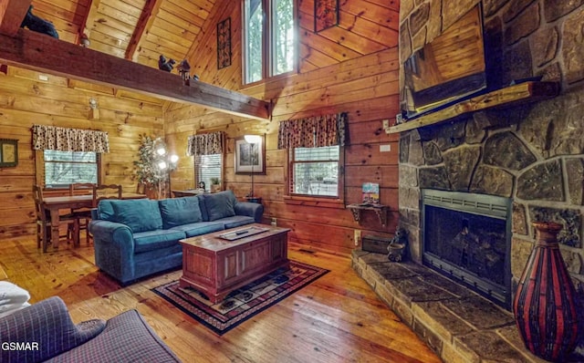 living room with wooden ceiling, a fireplace, light hardwood / wood-style floors, and wood walls