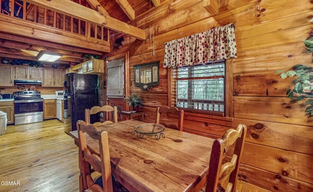 dining space with high vaulted ceiling, wood walls, wooden ceiling, beam ceiling, and light hardwood / wood-style flooring