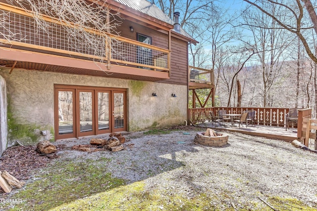 exterior space featuring stucco siding, a fire pit, and a deck
