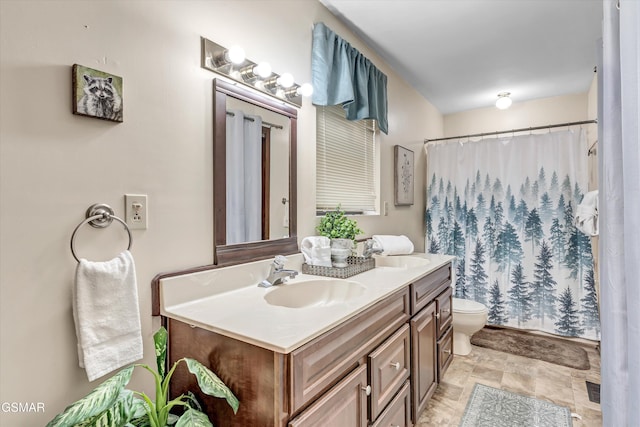 bathroom with toilet, vanity, and a shower with curtain