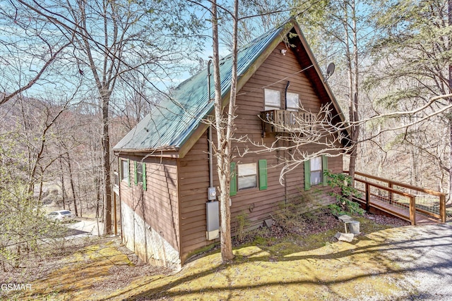 view of home's exterior featuring metal roof and a balcony