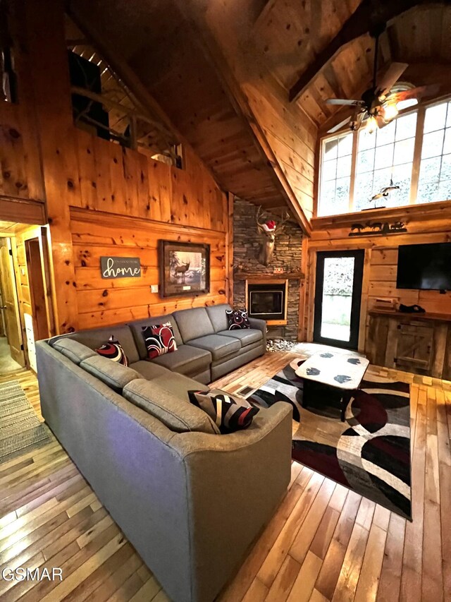 dining room with vaulted ceiling with beams, wooden walls, light hardwood / wood-style flooring, and wood ceiling