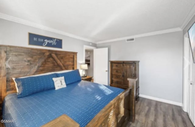 bedroom featuring crown molding and dark hardwood / wood-style floors