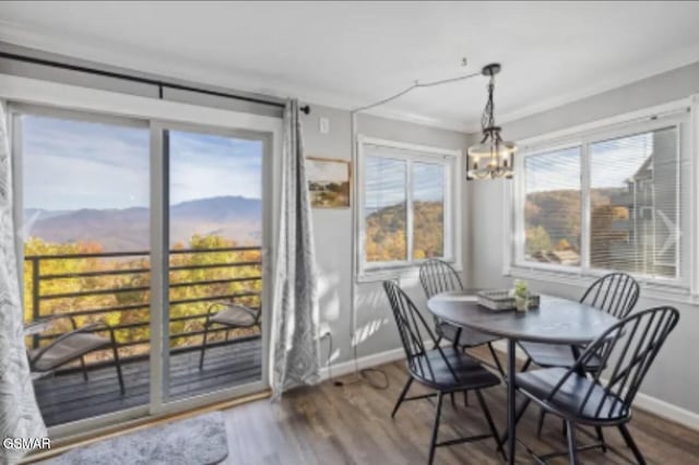 sunroom / solarium with a mountain view and a chandelier