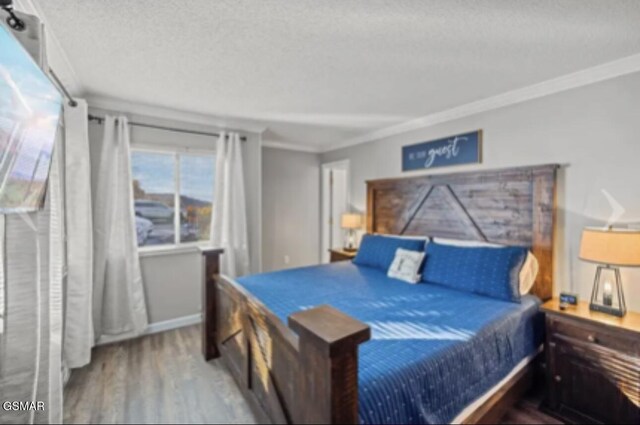 bedroom featuring hardwood / wood-style floors, a textured ceiling, and ornamental molding