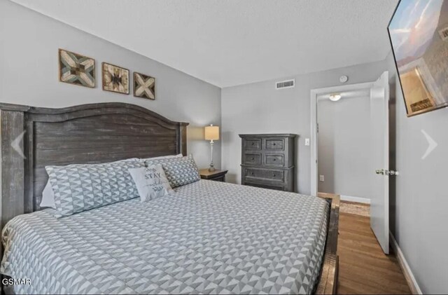 bedroom with dark wood-type flooring