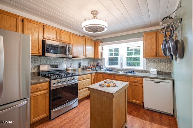 204 Hill St, Gatlinburg, TN 37738 - kitchen with stainless steel appliances, light wood finished floors, decorative backsplash, and a center island