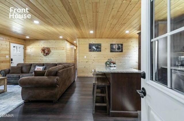 living area with dark wood-style floors, recessed lighting, wooden ceiling, and wood walls