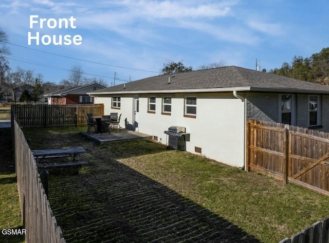 back of property with roof with shingles, a yard, a patio, crawl space, and a fenced backyard