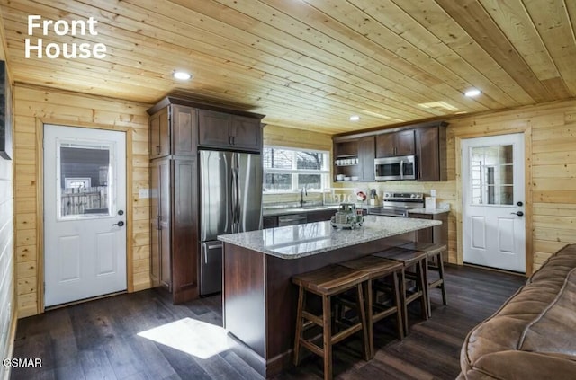 kitchen featuring wood ceiling, wooden walls, stainless steel appliances, and dark wood-style flooring