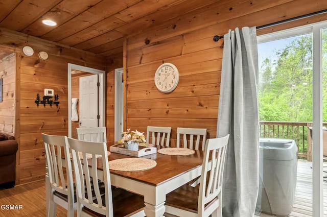 dining room featuring wood finished floors, wood ceiling, and wooden walls