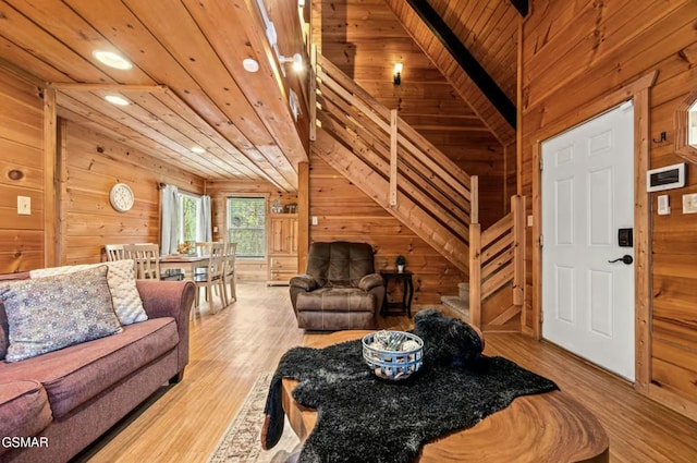 living area with lofted ceiling, wooden ceiling, wooden walls, and wood finished floors