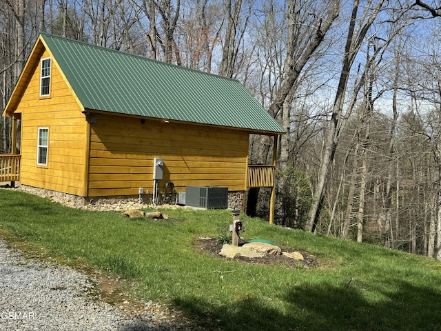 view of home's exterior with metal roof and central AC unit