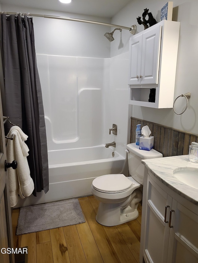 bathroom featuring toilet, shower / bath combo with shower curtain, vanity, and wood finished floors