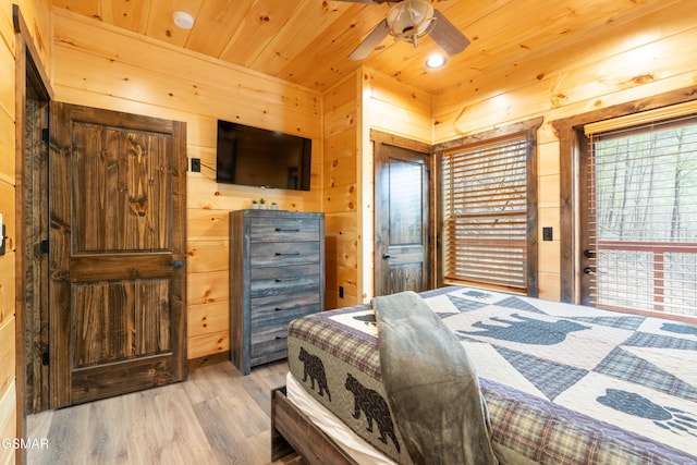 bedroom with ceiling fan, light hardwood / wood-style flooring, wood walls, and wood ceiling