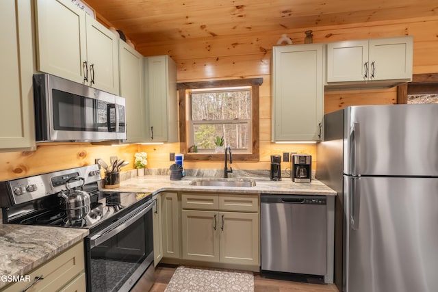 kitchen featuring wood walls, sink, appliances with stainless steel finishes, wood ceiling, and light stone counters