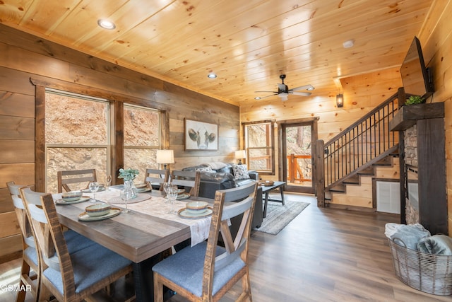 dining space with ceiling fan, wood ceiling, dark hardwood / wood-style flooring, and wooden walls