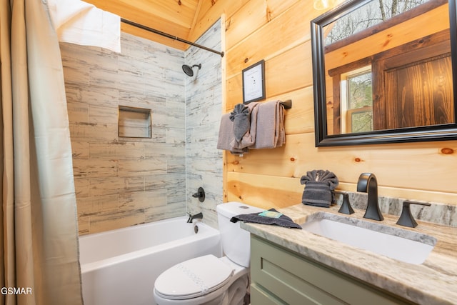 full bathroom featuring toilet, vanity, wood walls, and shower / bath combination with curtain