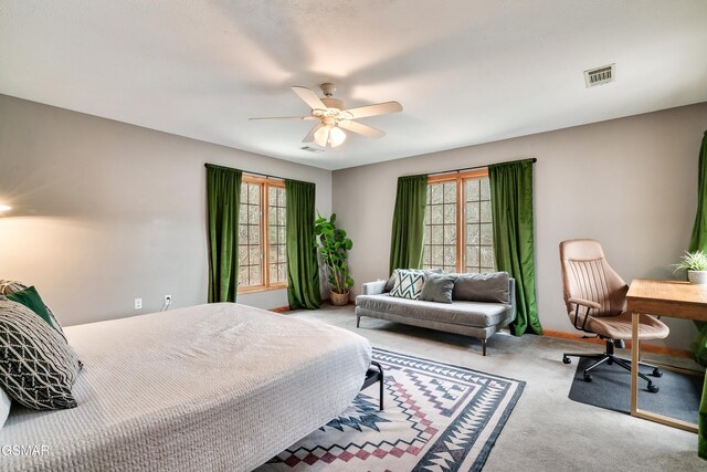 carpeted bedroom featuring a ceiling fan and visible vents