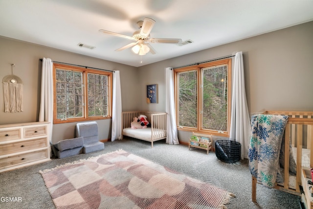 sitting room with carpet floors, visible vents, and a ceiling fan