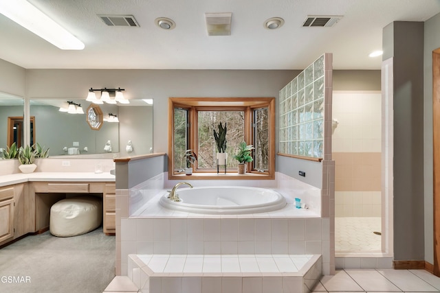 full bath with visible vents, a tile shower, a bath, and vanity