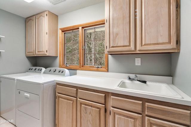 laundry room with cabinet space, a sink, and washer and clothes dryer