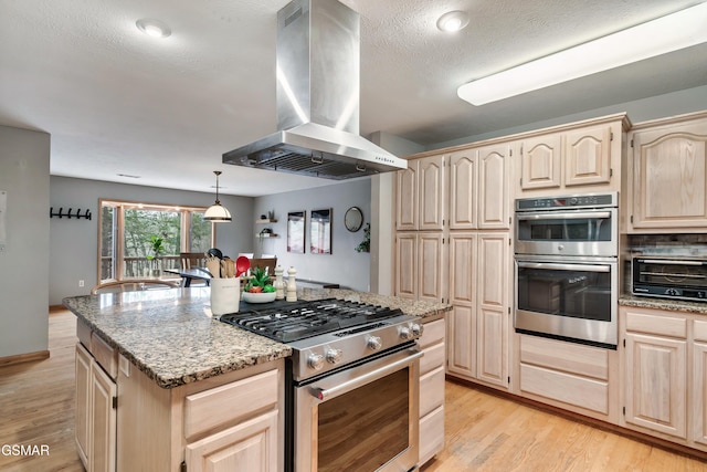 kitchen featuring stainless steel appliances, light wood-type flooring, ventilation hood, and light brown cabinetry