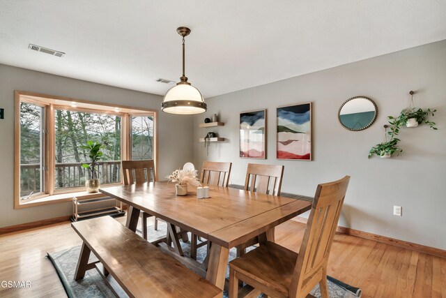 dining area featuring light wood-style floors, baseboards, and visible vents