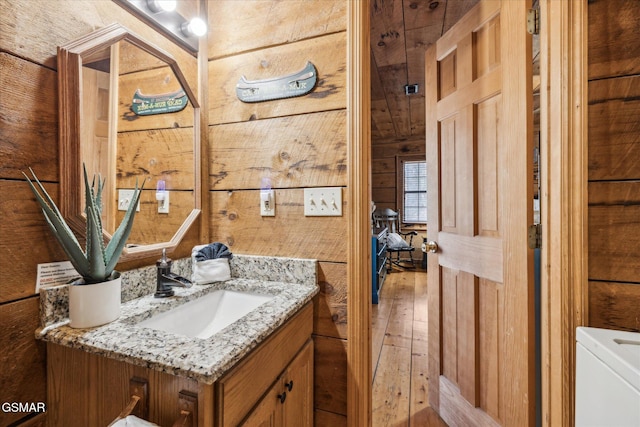 bathroom featuring vanity and wooden walls