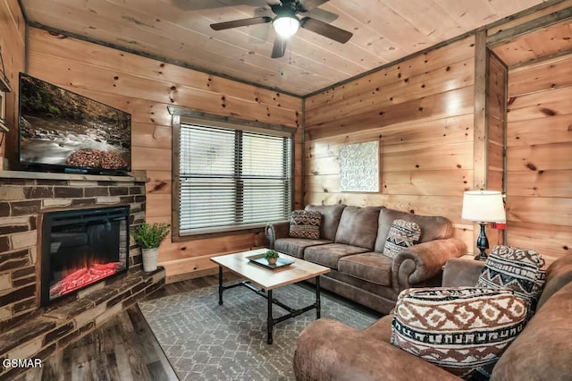 living room featuring a stone fireplace, wooden ceiling, wooden walls, and wood finished floors