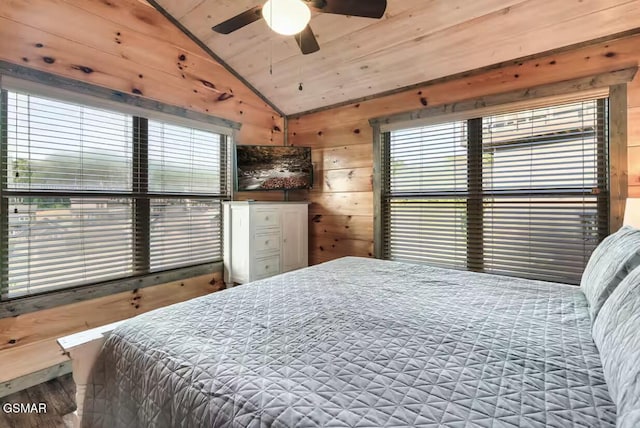 bedroom with vaulted ceiling, wooden walls, multiple windows, and wooden ceiling