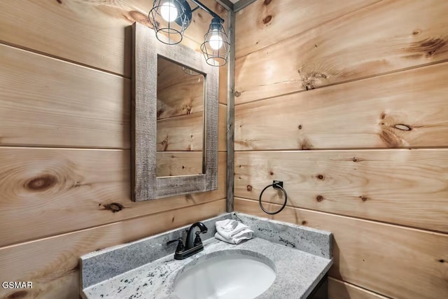 bathroom featuring wooden walls and vanity