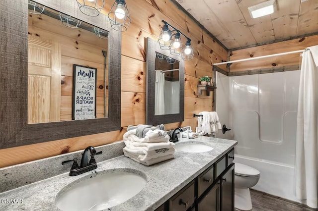 full bath featuring a sink, double vanity, wood walls, and wooden ceiling