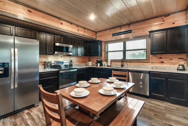 kitchen with light wood-type flooring, appliances with stainless steel finishes, wooden ceiling, and light countertops