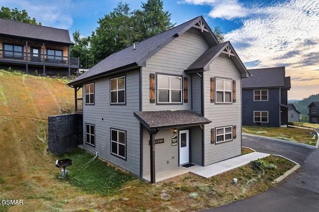 view of front of property featuring aphalt driveway and roof with shingles