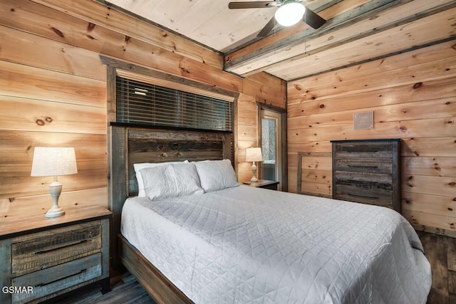 bedroom featuring beamed ceiling, wooden walls, and wood finished floors