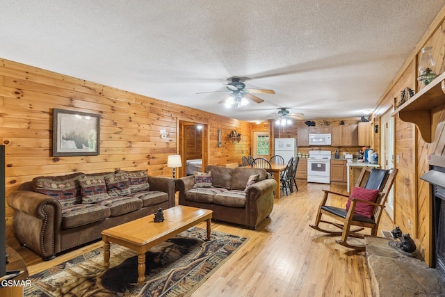 2112 Redmond Way, Sevierville, TN 37876 - living room with a textured ceiling, ceiling fan, light wood finished floors, and wood walls