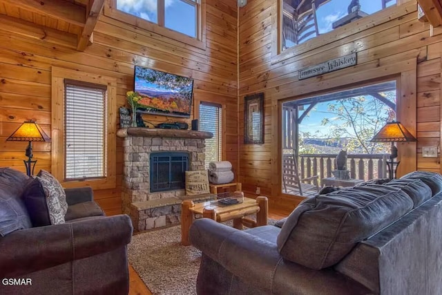 living room with wood walls, a fireplace, and beamed ceiling